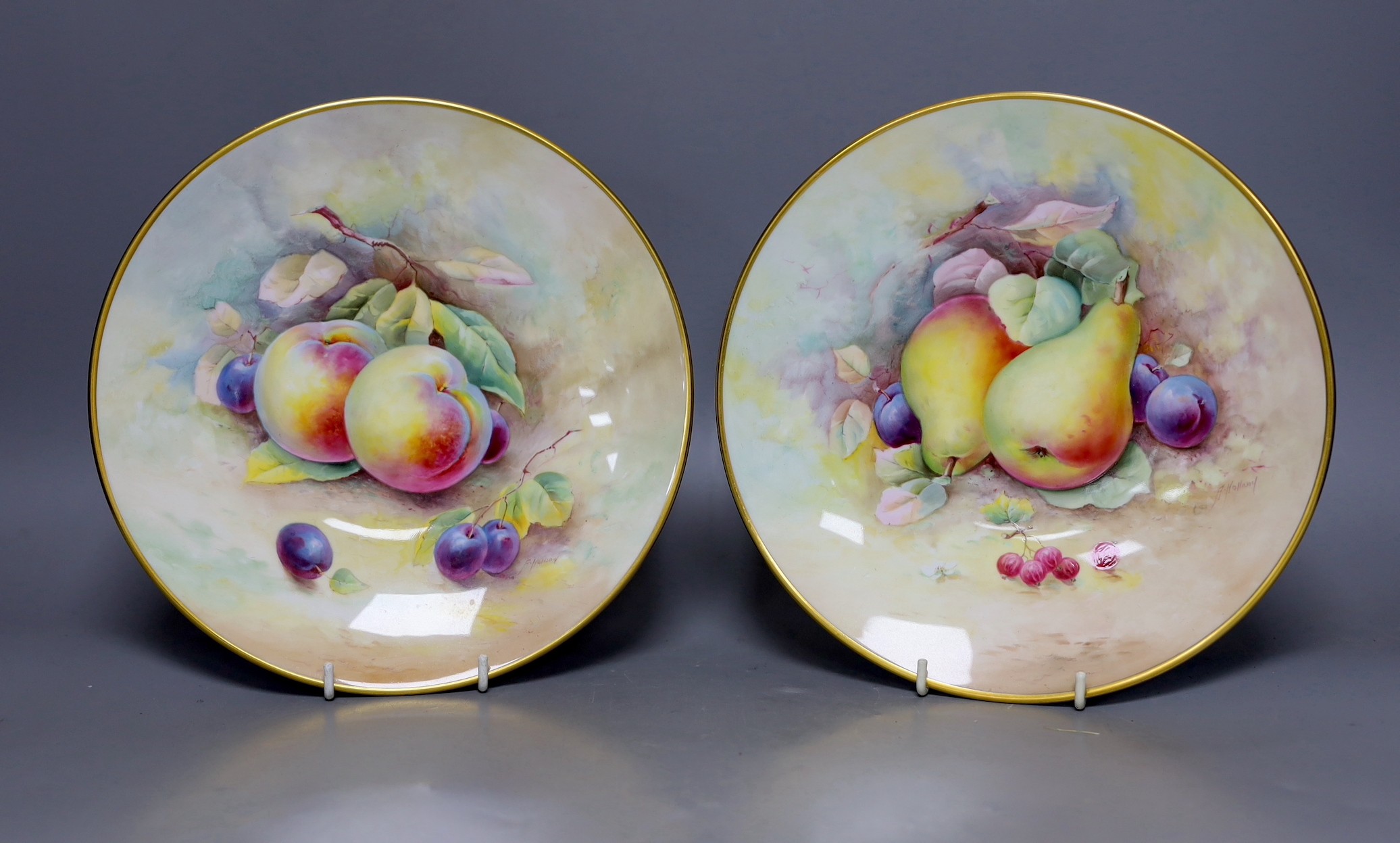 A pair of Minton fruit painted plates, signed A. Holland, 23cm diameter, together with two books on Coalport